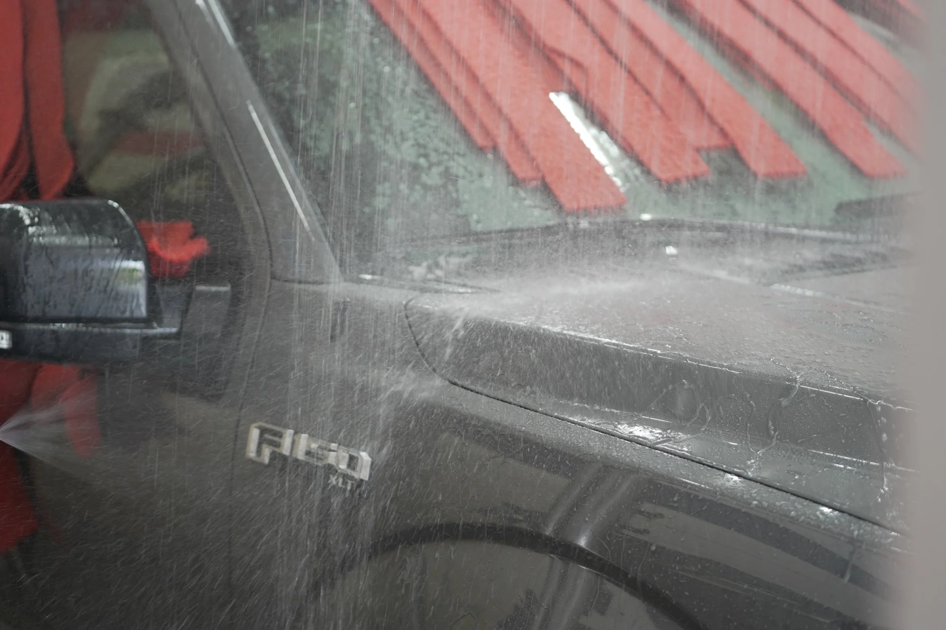 Soft-cloth car wash spraying a Ford F-150 at High Street Car Wash, Oakland