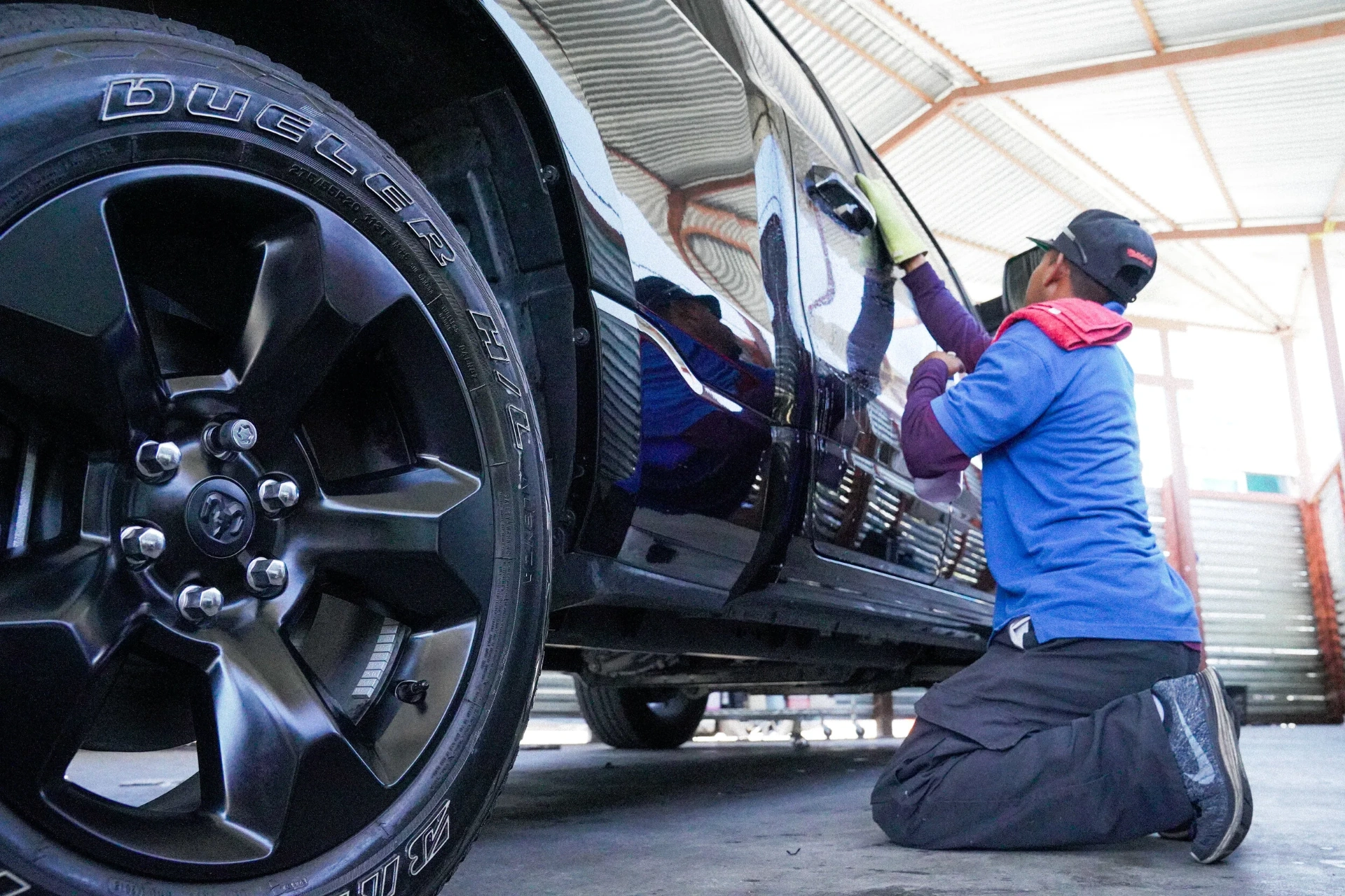 Hand detailing the side of a truck with a buffing pad